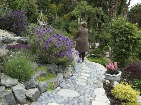 Bea Johnson lingers on a path in her garden