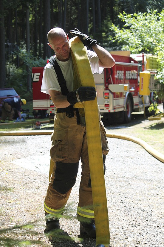VIFR firefighter and paramedic Andy Johnson cleans up at a fire that damaged a south-end home.