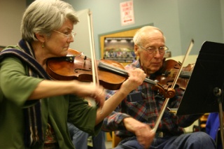 Violinists Gaye Detzer and Russ Nelson concentrate on the task at hand.