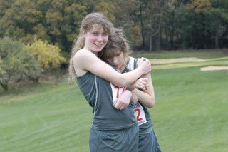 Savannah Krug is jubilant as she hugs exhausted Leigh Sheridan after the pair of Pirate sophomores qualified for the state cross-country meet. Krug finished 15th overall and Sheridan 26th in the Westside Classic Tri-District Meet on Saturday.