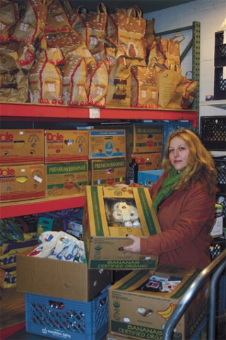 Kelli Brown hoists a box onto the now full shelves at the food bank.