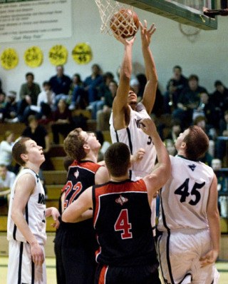 Josh Cox shoots over the Warriors’ defense Feb. 3 in his first appearance for the Pirates varsity.