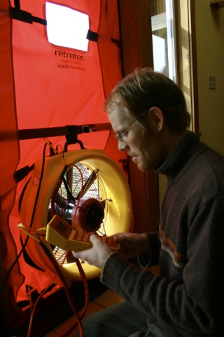 Charlie Rogers sets up a blower door at the common house at Vashon Cohousing.