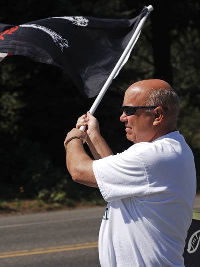 Chief Hank Lipe waves the Pirate flag at a Vashon Pirate Youth Football party Saturday.