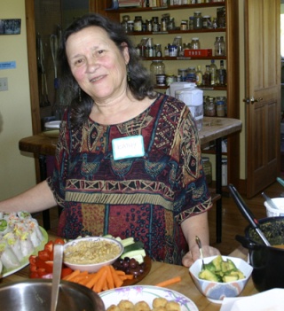 Kathy Abascal stands before a spread of food at Vashon Cohousing during a recent potluck featuring the anti-inflammatory foods she advocates.