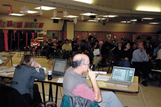 School board members Kathy Jones and John “Oz” Osborne listen to Islanders discuss the proposal.