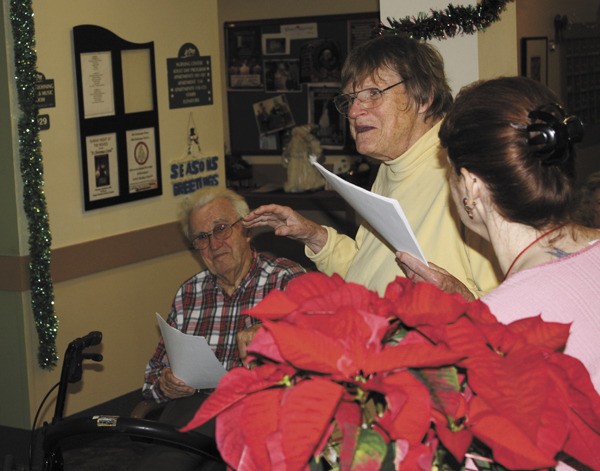 Elizabeth Anthony leads several VCC residents in Christmas carols last week.