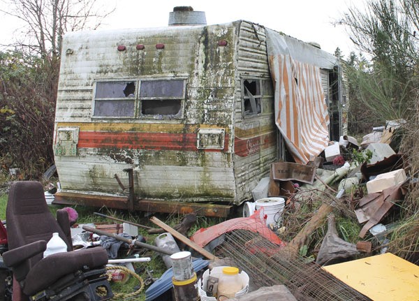 A moldering trailer surrounded by junk and debris recently appeared at a vacant lot south of town.