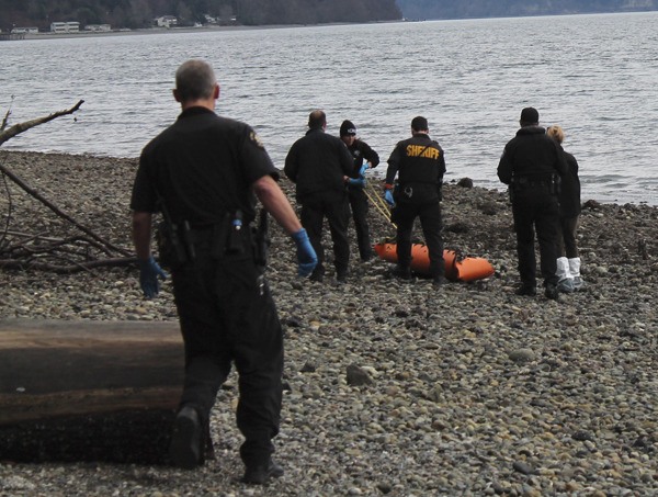 Officials from King County Sheriff’s Office and the Medical Examiner’s Office remove the body.