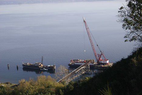 Glacier barged a construction crane to its site off of Maury Island to begin construction last December. It hopes to resume building its controversial pier Aug. 15.