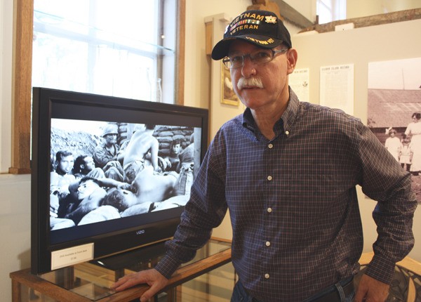 Chris Gaynor stands by the monitor that displays his photos at the museum.