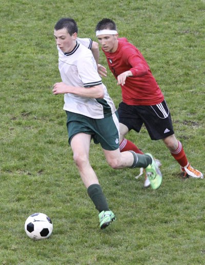 Pirate soccer player Sean O’Neil is pursued by an Orting midfielder during a game on March 27. O’Neil scored the Pirates’ third goal to secure their win.