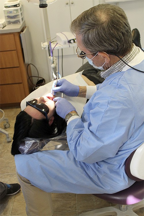 Dentist Cliff Eckman treats a patient at the dental van last week. Since 2012