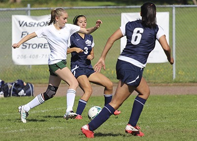 Pirate freshman Katherine Andrus fends off two Cedar Park Eagles in the race to the ball in Saturday’s game. Andrus scored two goals for the Pirates.