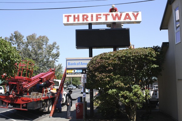 A worker installs the new sign at Thrifway last week.