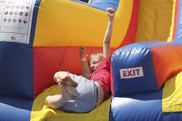 A boy enjoys an inflatable slide at last year’s Strawberry Festival. This year the carnival will feature similar inflatable structures as well as more activities