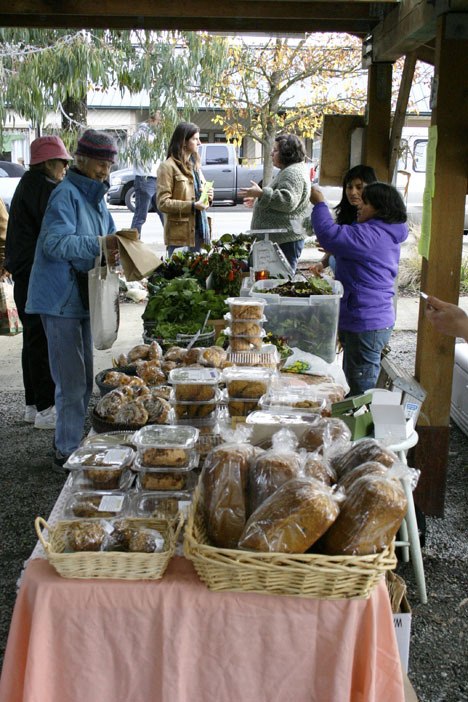 Customers purchase greens at a recent Farmers Market at the Village Green.