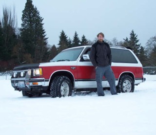 Barrett Fox stands in the snow in front of his Chevy Blazer.