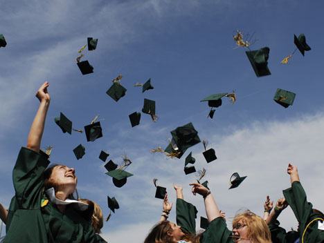 Seniors are jubilant as they toss their caps into the sky after they graduated on Saturday