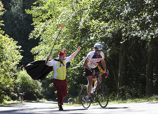 Vashon's own Burma Road Devil 'helping' a rider during last year's Passport to Pain cycling event.
