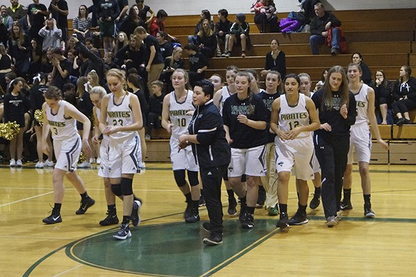 The girls’ varsity basketball team leaves the court after opening introductions at a recent game.
