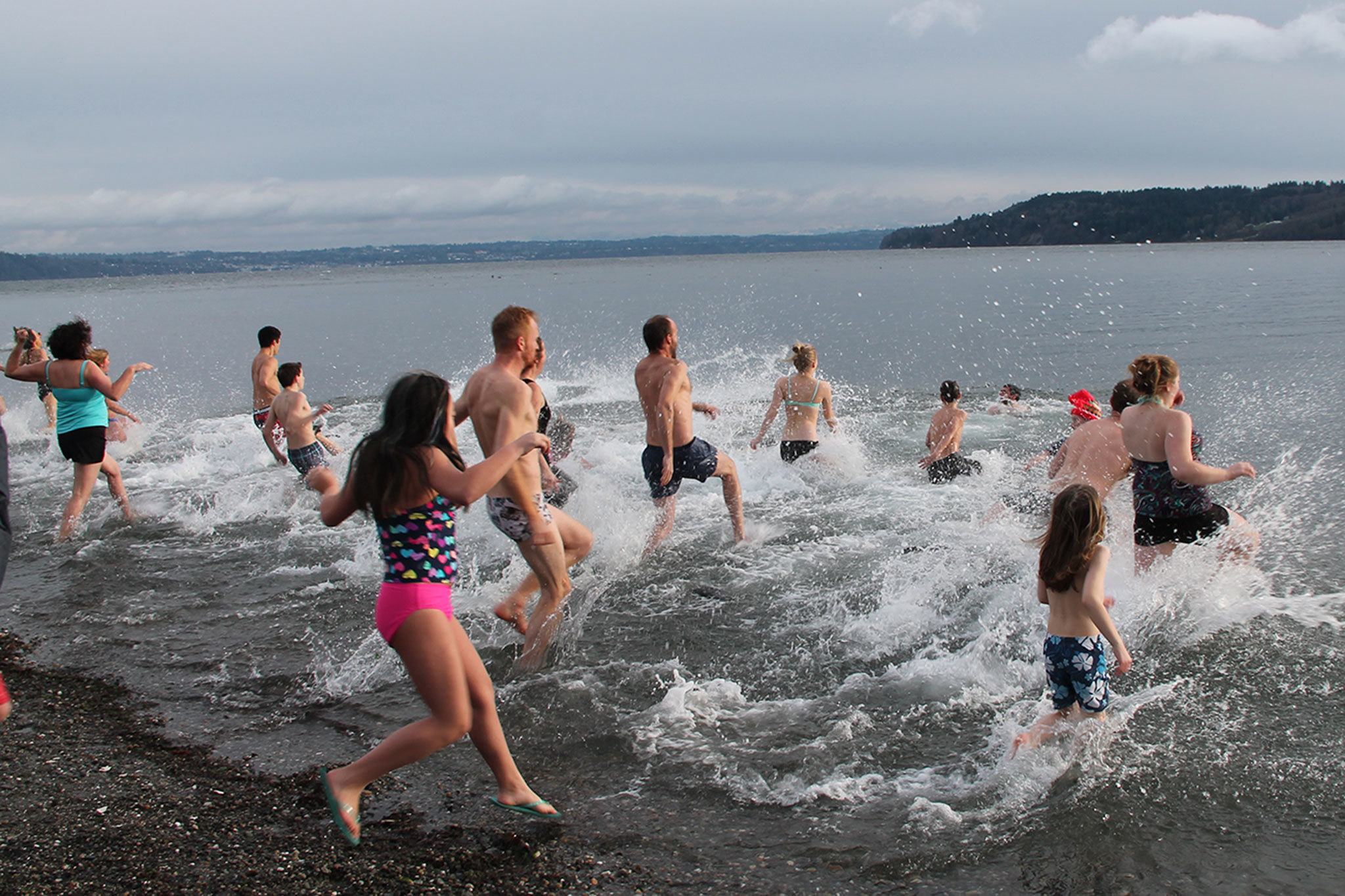 Plungers run into the water yelling and cheering on Sunday afternoon. (Anneli Fogt/Staff Photo)