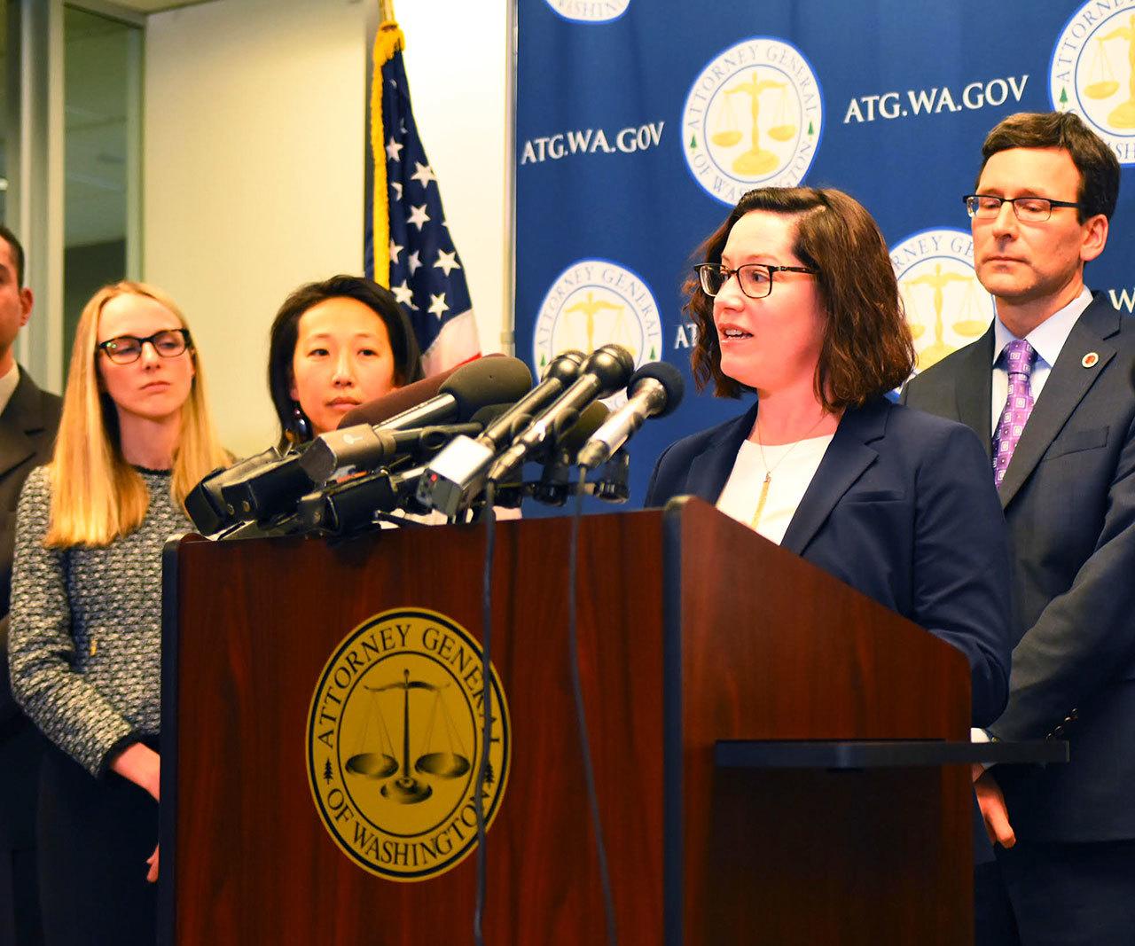 Colleen Melody (at podium) and Washington State Attorney General Bob Ferguson (back right) at a recent press conference. (Courtesy Photo)