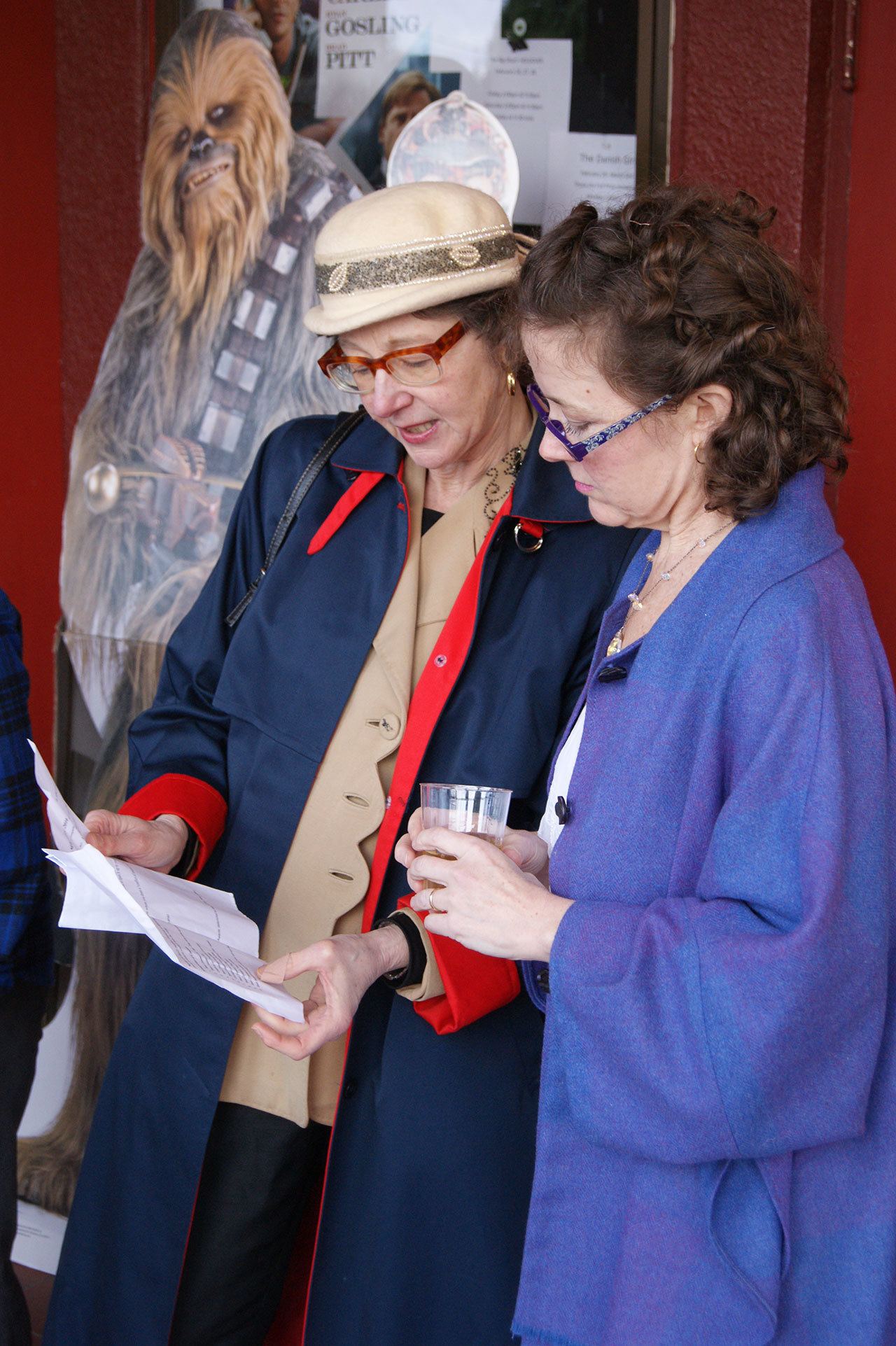Oscar Night party-goers review the list of Oscar nominees and the evening’s schedule ahead of 2016’s Oscar Night event at the Vashon Theatre. (Anneli Fogt/Staff Photo)