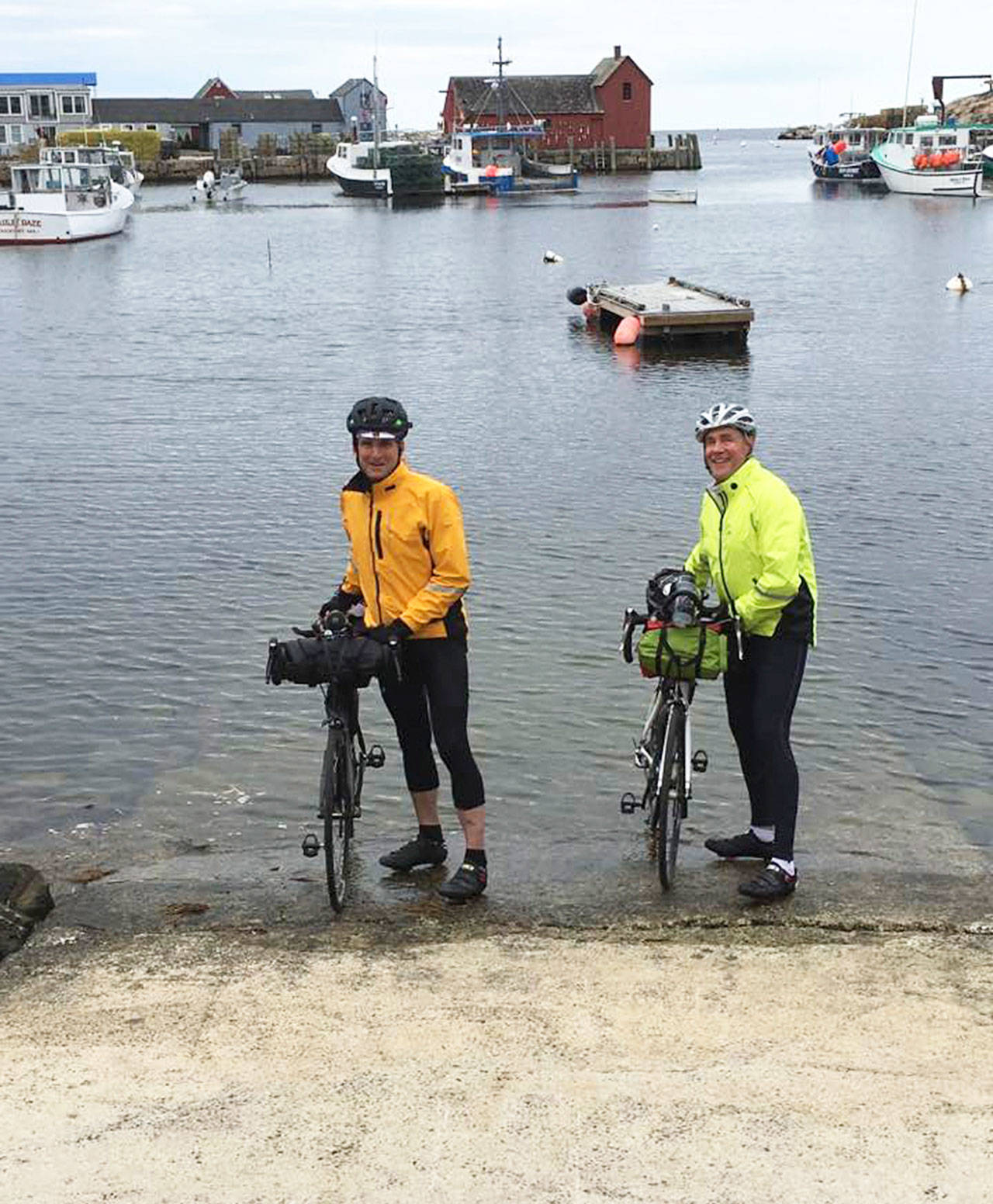 Islanders Bob Horsley (left) and Bruce Morser (right) dip their tires in the Atlantic Ocean Monday before heading on their two-month-long cross-country ride back to Vashon. (Courtesy Photo)