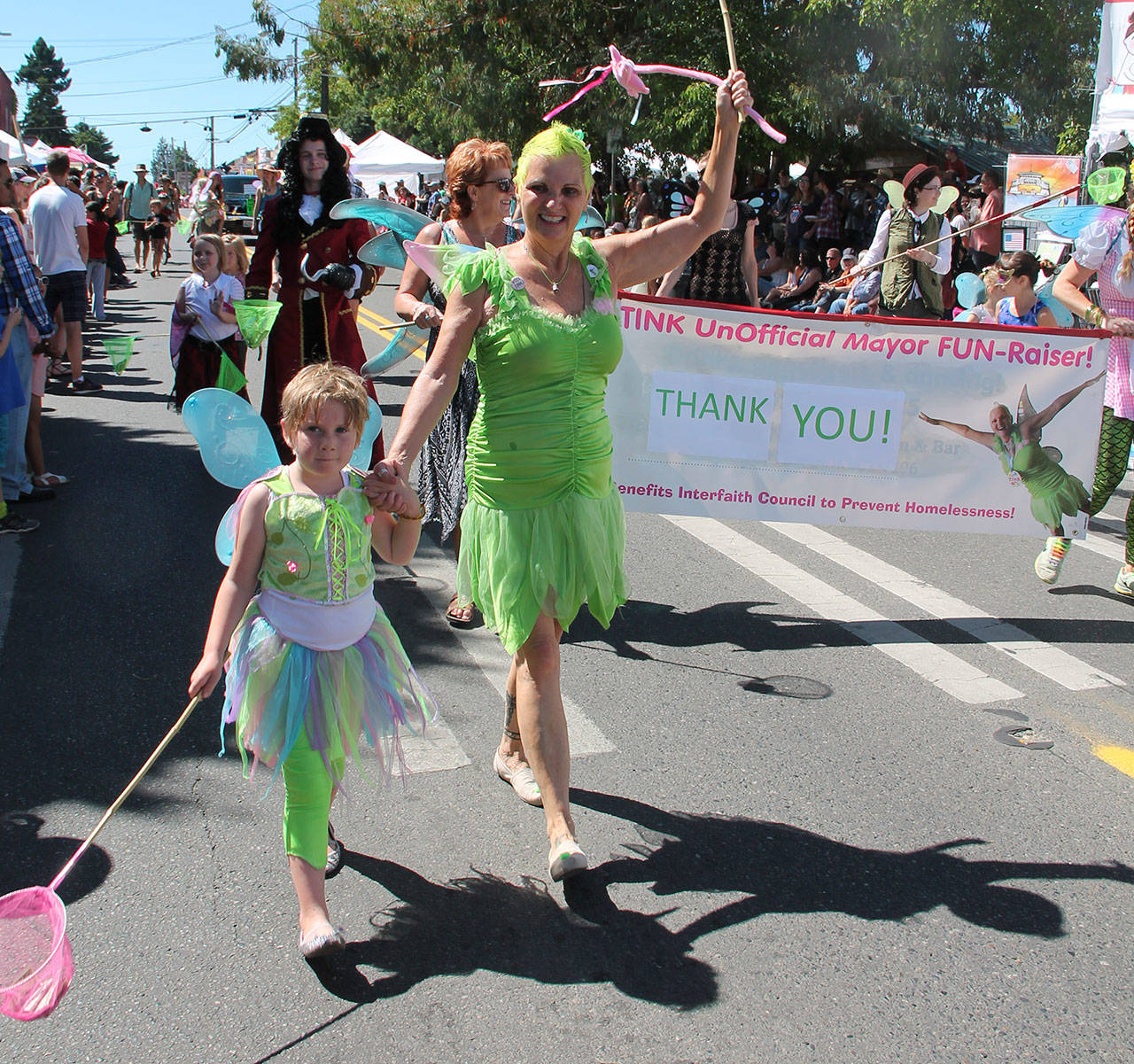 Tink walks in the parade with her young friend Millie. (Susan Riemer/Staff Photo)