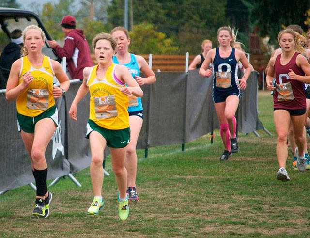 Pirates Ella Yarkin and team captain Lucy Boyle (in yellow) race along the barriers during the Hole in the Wall Invitational in Lakewood. Both girls went on to set records on the 5-kilometer course: Yarkin finished with a personal best time of 21:29, and Boyle finished with a season-best time of 21:41. (Jeff Johnston Photo)
