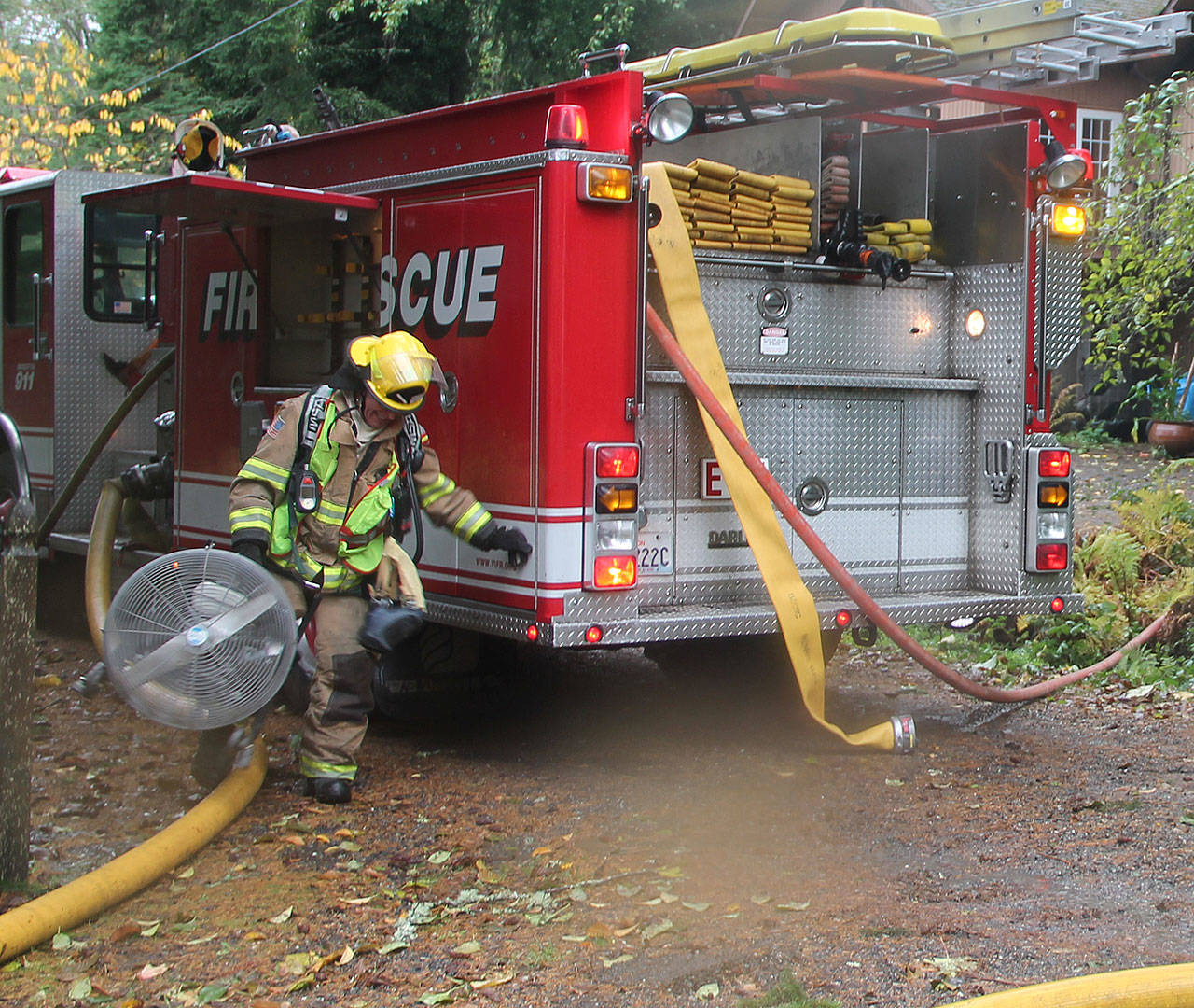 With the passage of the fire district’s levy, VIFR is working to hire more firefighters, both full and part time. Above, volunteer firefighter Mike Kirk assists at last week’s house fire. (Susan Riemer/Staff Photo)