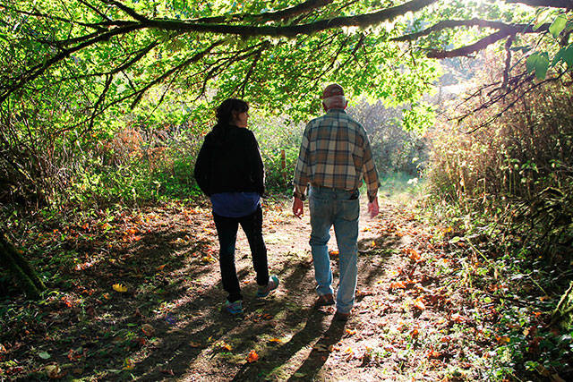 Director Annie O’Neil, left, and Phil Volker walk Phil’s Camino in the late afternoon light on Vashon. (Juli Goetz Morser/Staff Photo)