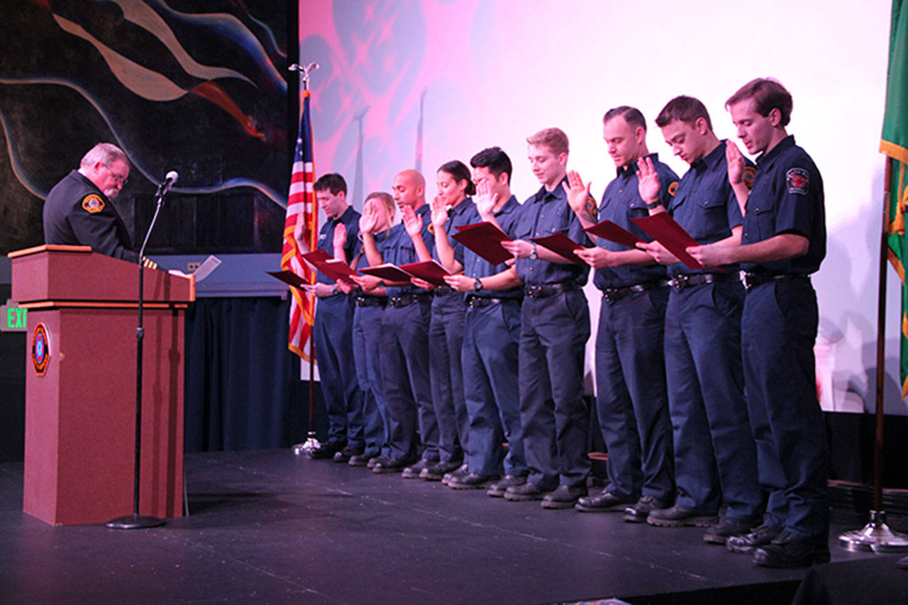 Assistant Chief Bob Larsen leads the group in the firefigher’s oath. (Susan Riemer/Staff photo)