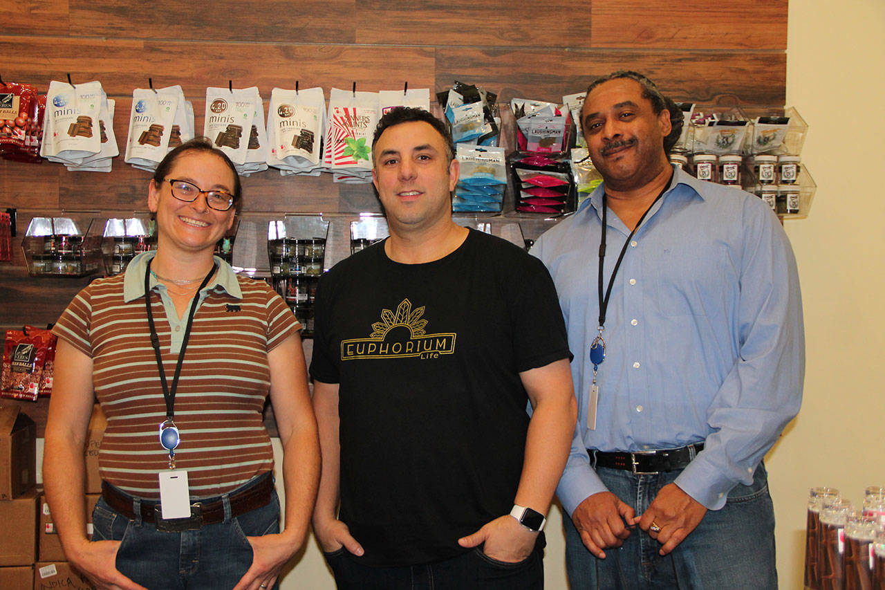 Euphorium co-owner Ben Bentitou, center, and two employees pause for a photo while stocking the shelves on the store’s opening day. (Sarah Low/Staff Photo)