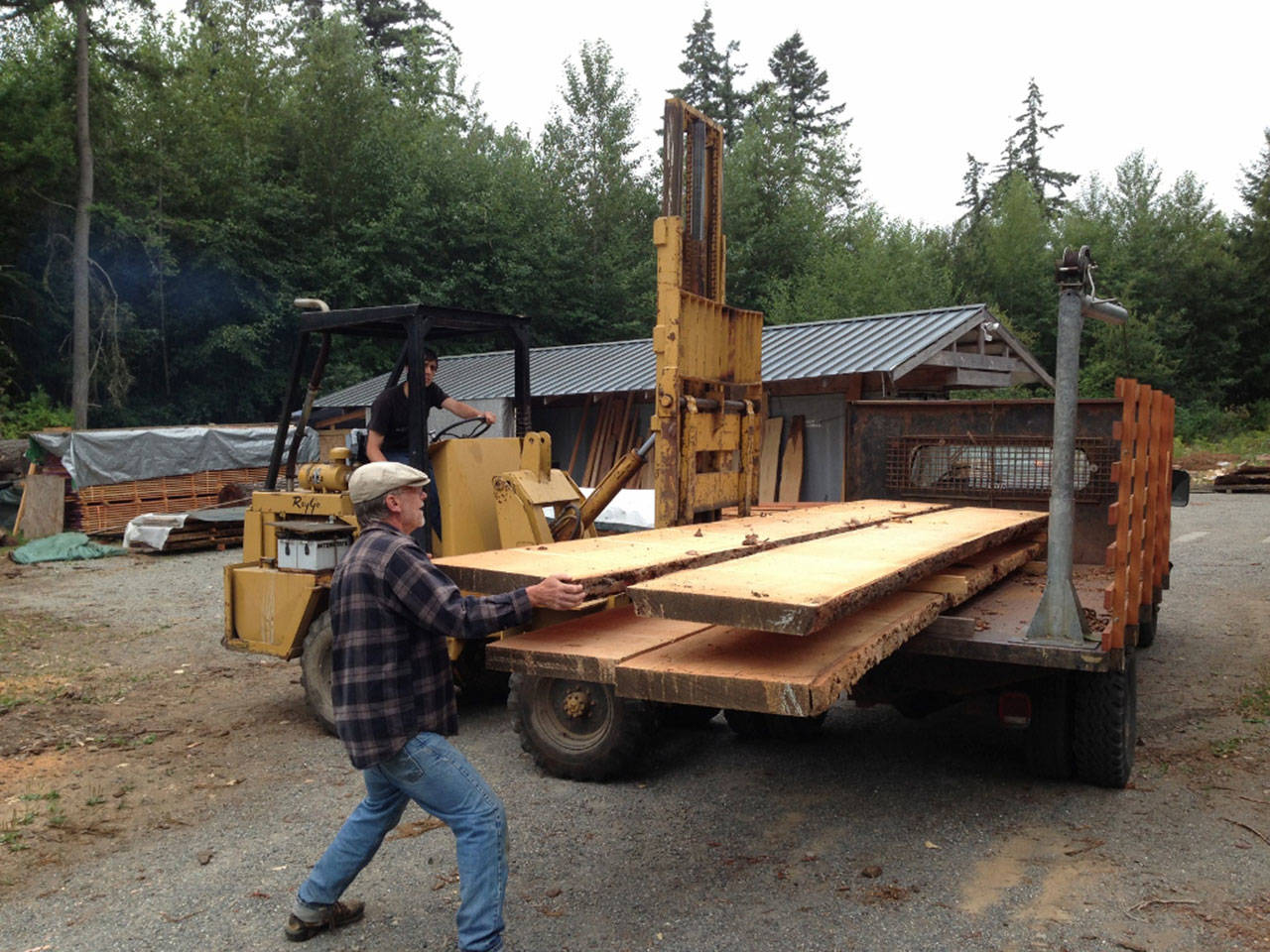 Woodworker Hans Nelsen loads large fir planks from the VFS mill yard. (Courtesy Photo)