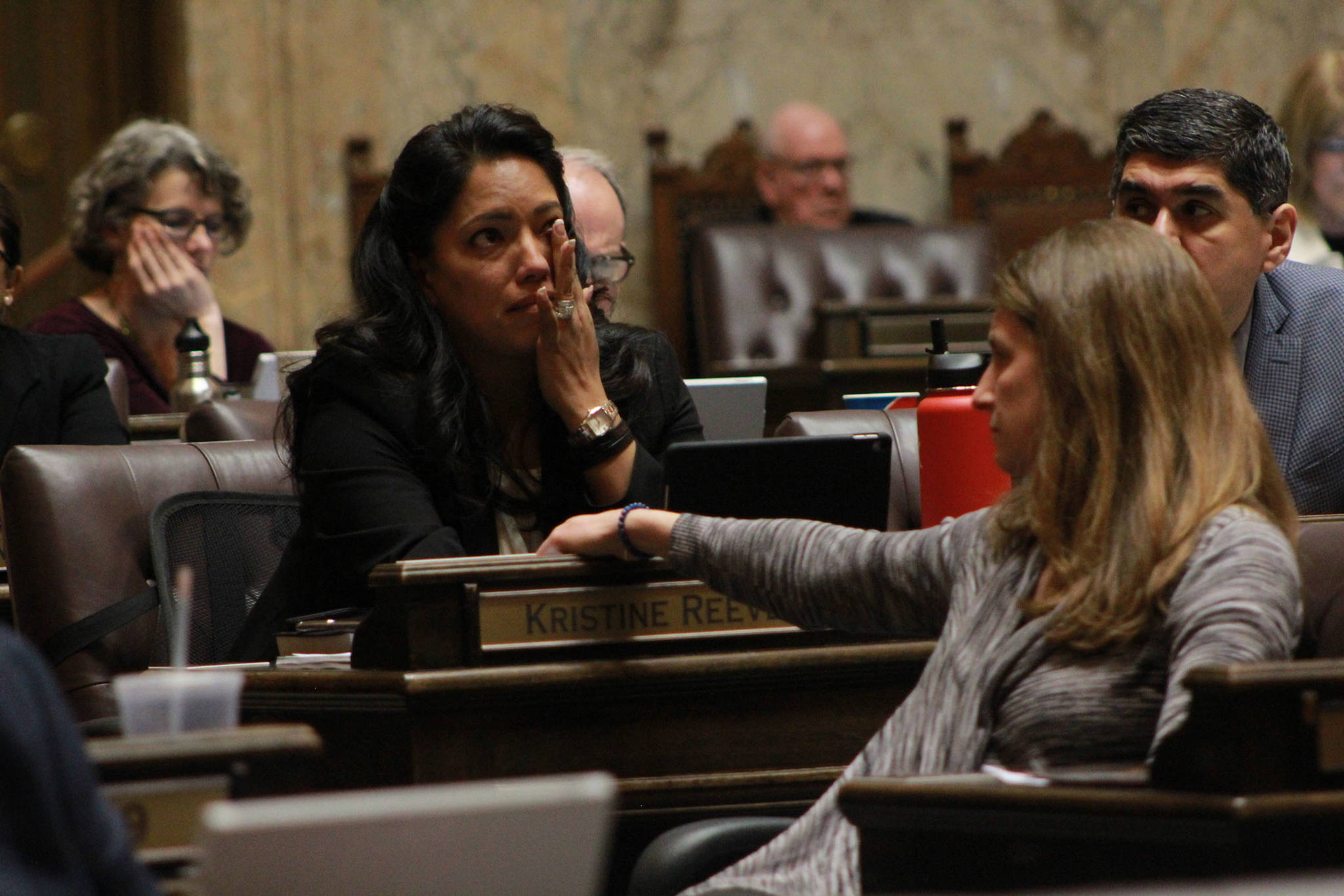 Rep. Kristine Reeves, D-Federal Way, battled tears during the House floor debate on a bill to ban bump stocks, while her colleague Tana Senn, D- Mercer Island turned to comfort her. Photo by Taylor McAvoy