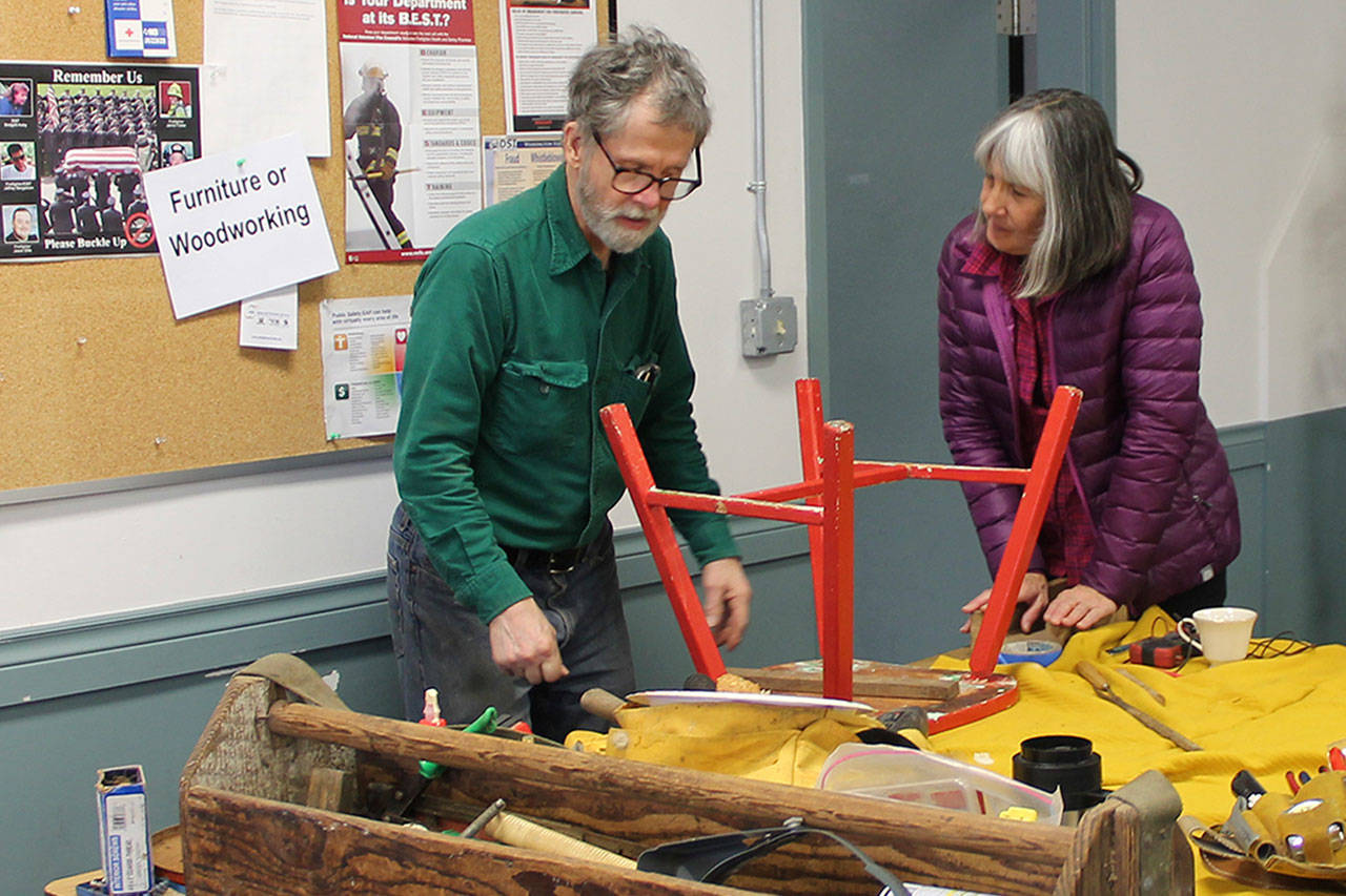 Terry Sullivan repairs a chair for Carolyn Candy at a Fix-it Cafe last year. (File Photo)