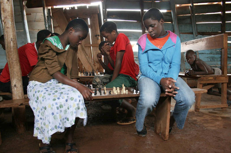 Phiona Mutesi, right, plays chess as a young girl in Uganda. (Courtesy Photo)