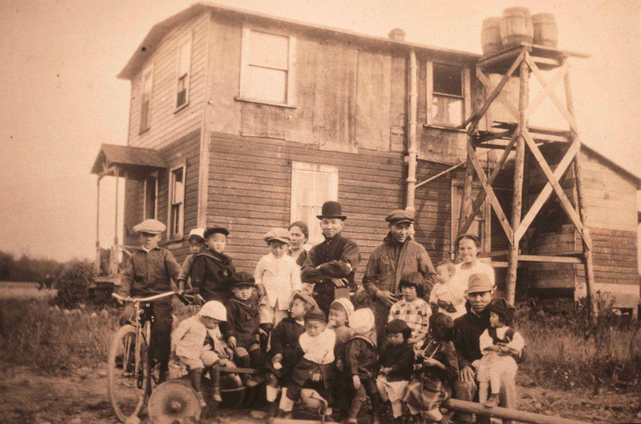B.D. Mukai with farm workers and children at his farm in about 1915.