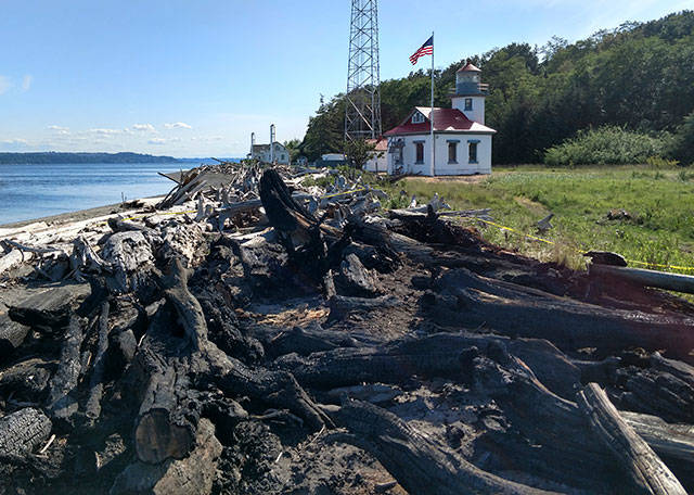 Susan Riemer/Staff Photo                                Charred logs on the beach at Point Robinson are the remnants of last week’s fire.