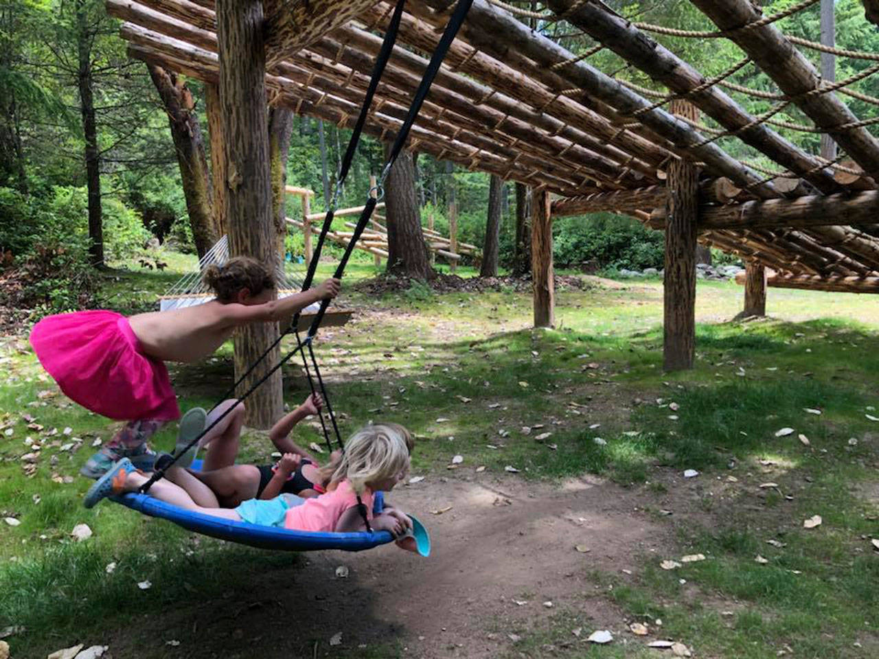 The children at Isabelle’s Playschool enjoy the saucer swing located under one of the climbing structures built with logs from the property. (Isabelle Porter Photo)