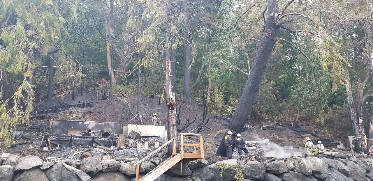 Charred ground, trees and foundation are all that is left after an overnight fire burned two west side homes. (Christopher Overdorf Photo)