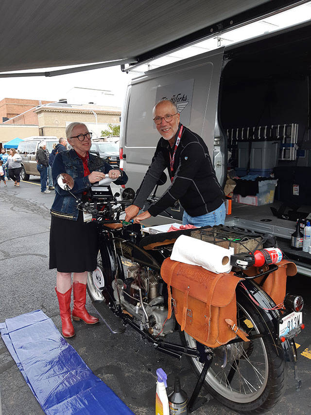 Nancy and Chris O’Brien tend to Chris’ vintage motorcycle under the awning of their van.                                Courtesy Photo                                Nancy and Chris O’Brien tend to Chris’ motorcycle under the awning of their van (Courtesy Photo).