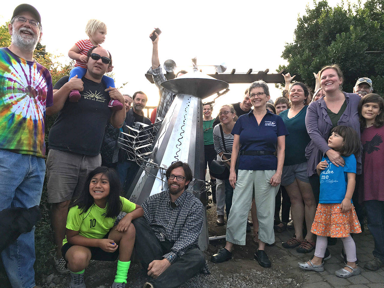 Artist Ela Lamblin, seated center, joins a group of students, parents and teachers for the unveiling of a new sculpture he helped create to celebrate Vashon Artists in the Schools (Courtesy Photo).