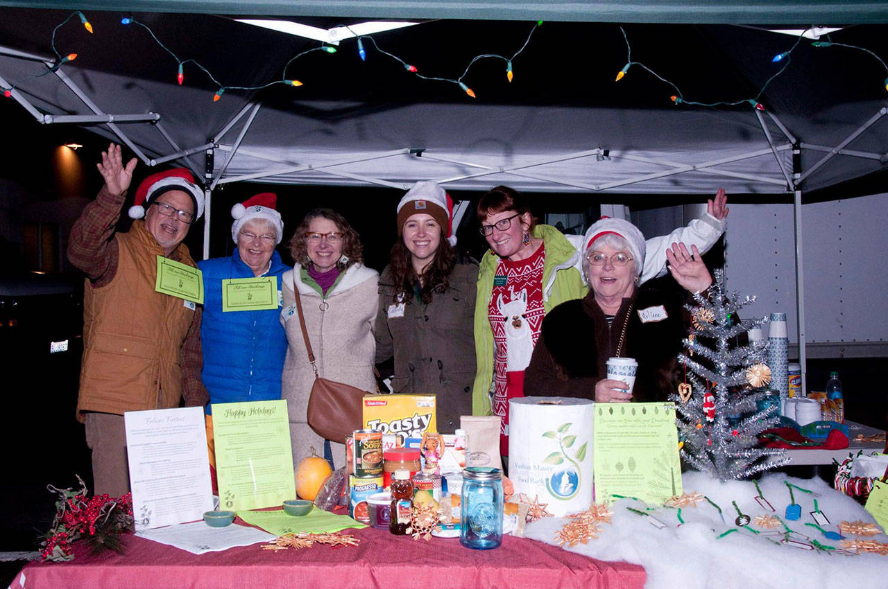 Food bank staff and volunteers gather at the donation table during the Dec. 1 event. (Courtesy Photo)