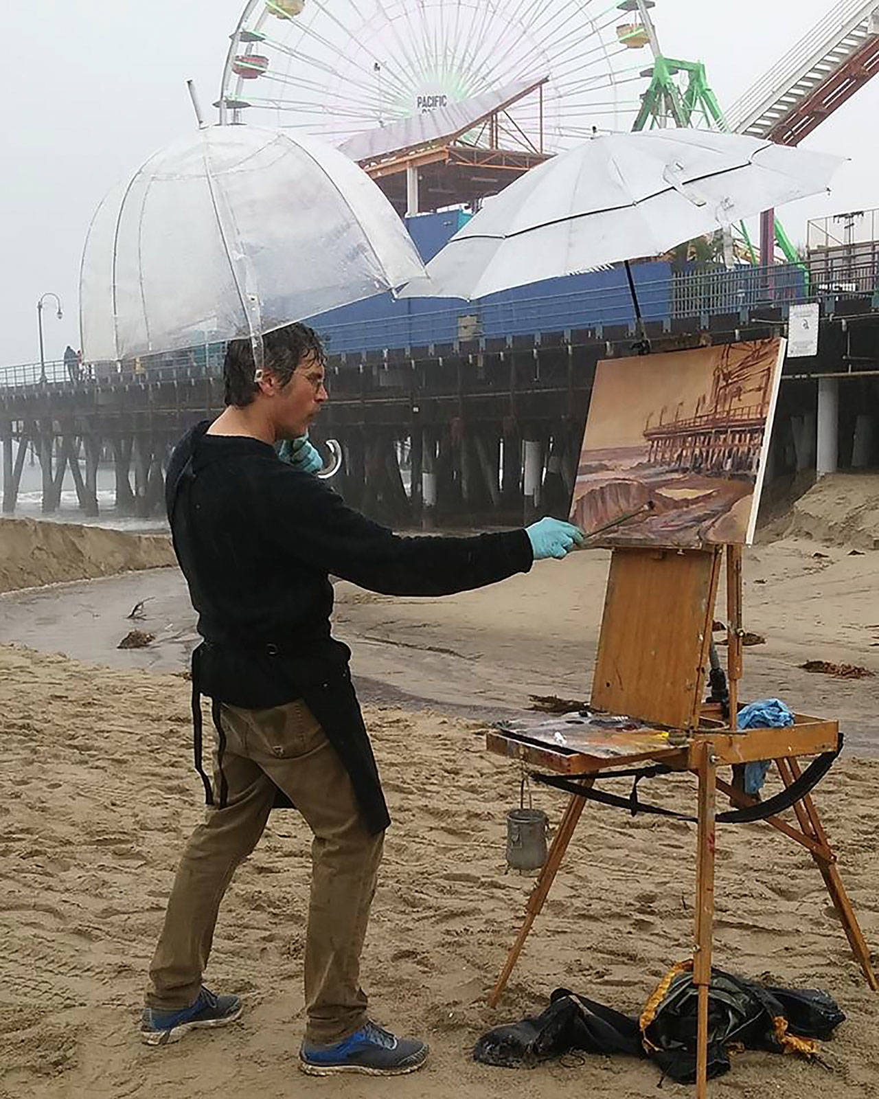 Steffon Moody, shown here painting in the rain at the Santa Monica Pier, will have his third annual solo show at The Hardware Store Restaurant Gallery (Courtesy Photo).