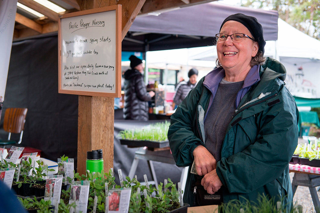 Michelle Crawford of Pacific Potager sells plant starts at the opening day of the market last year. (File photo)