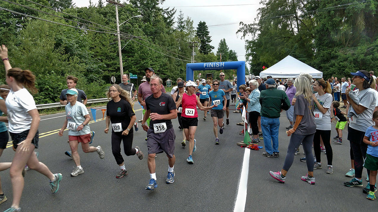 Runners cross the finish line at a past Bill Burby race (Mike Kirk Photo).