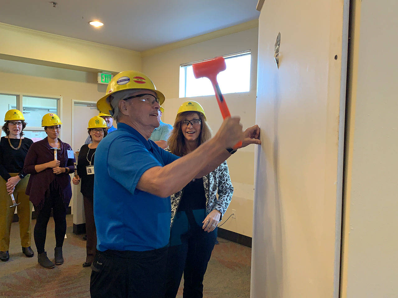 Vashon Community Care resident John Whitney hammers out a piece of wall in the facility to mark the start of construction on the memory care wing on Thursday, Oct. 24 (Kevin Opsahl/Staff Photo).